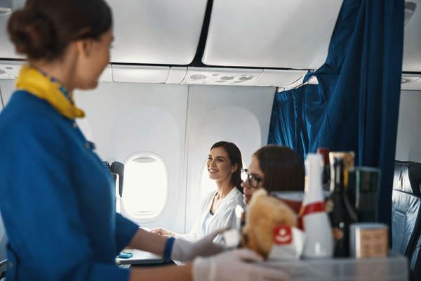 Cabin crew serving passengers in an airline interior
